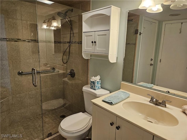 bathroom with vanity, a shower with shower door, and toilet