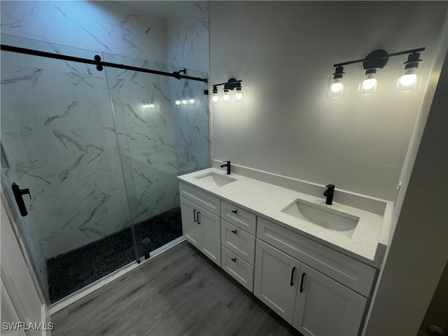 bathroom featuring a tile shower, vanity, and wood-type flooring