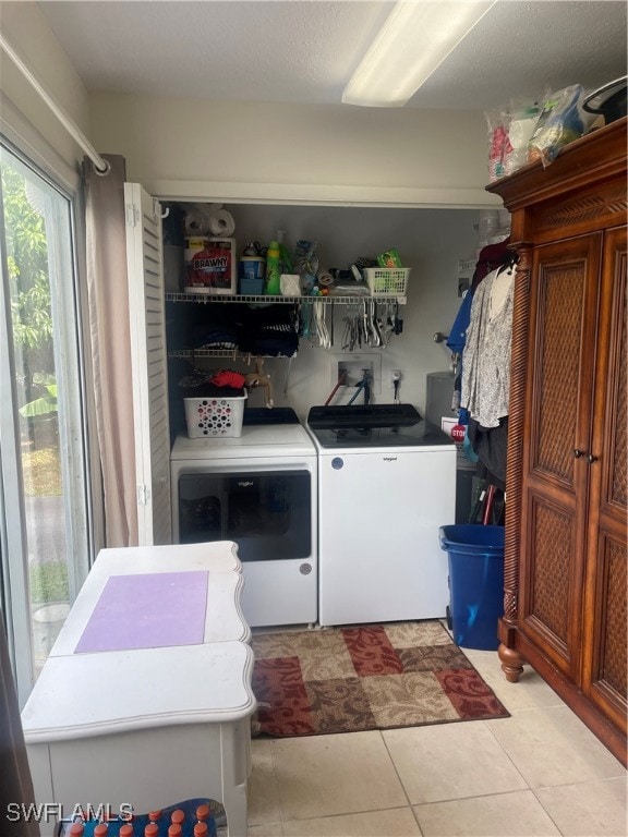 laundry area featuring washer and dryer and light tile patterned floors