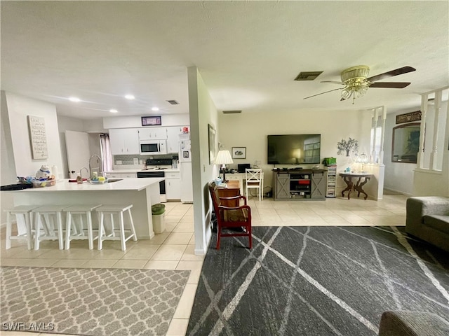 tiled living room featuring ceiling fan, a textured ceiling, and sink