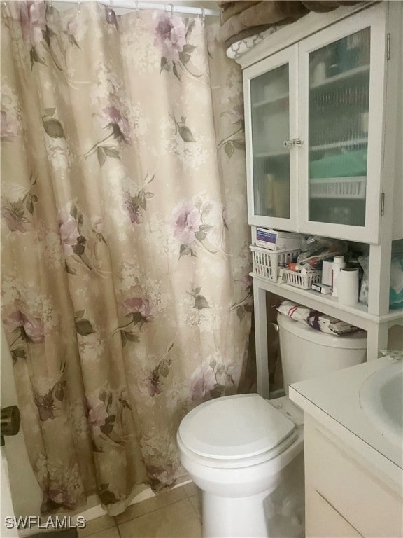 bathroom featuring vanity, curtained shower, toilet, and tile patterned floors