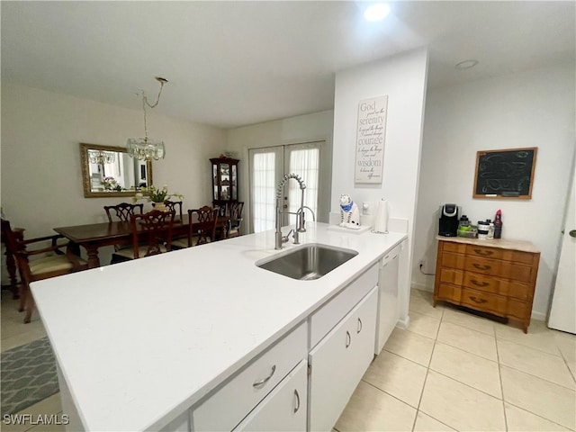 kitchen with dishwasher, a kitchen island with sink, sink, a notable chandelier, and white cabinets