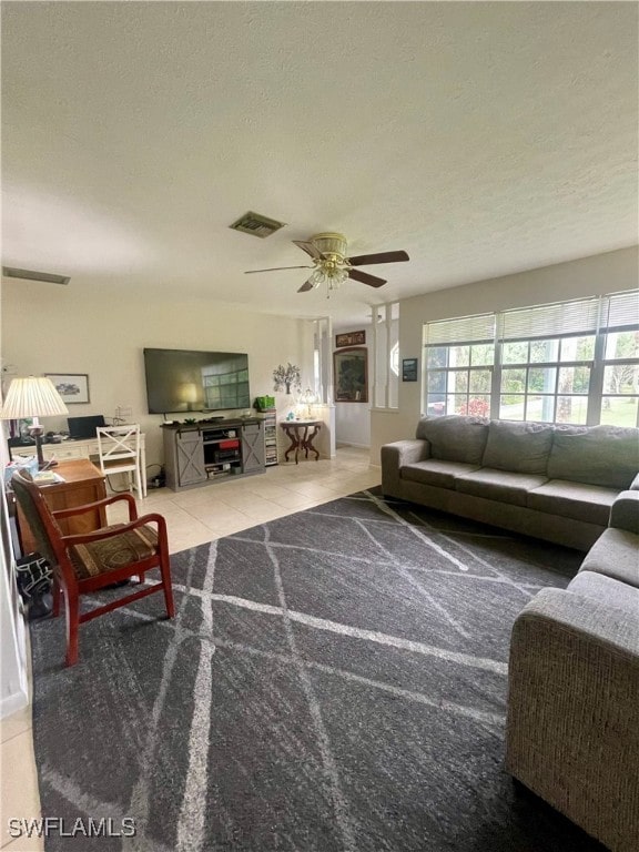 tiled living room featuring a textured ceiling and ceiling fan