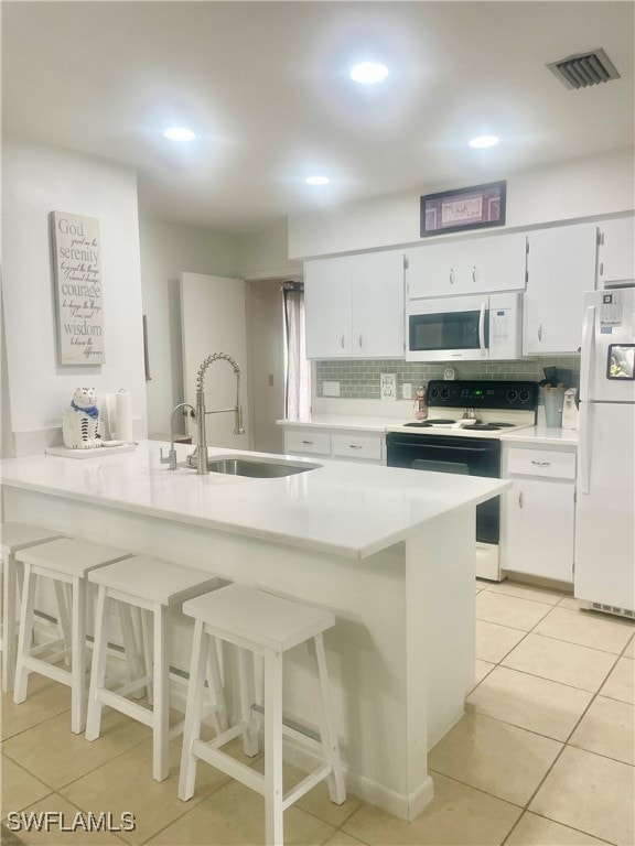 kitchen with decorative backsplash, white cabinetry, sink, and white appliances