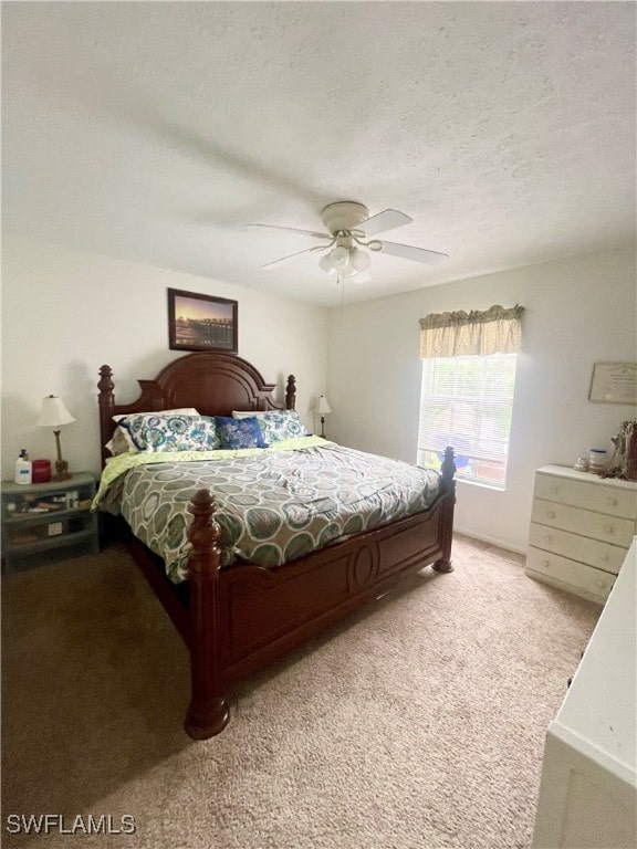 bedroom featuring light carpet, a textured ceiling, and ceiling fan