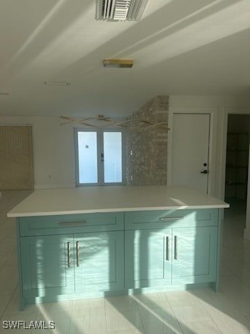 kitchen featuring light tile patterned floors, tile walls, and green cabinetry