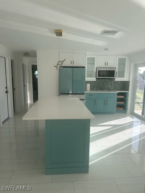 kitchen featuring backsplash, stainless steel appliances, sink, decorative light fixtures, and white cabinetry