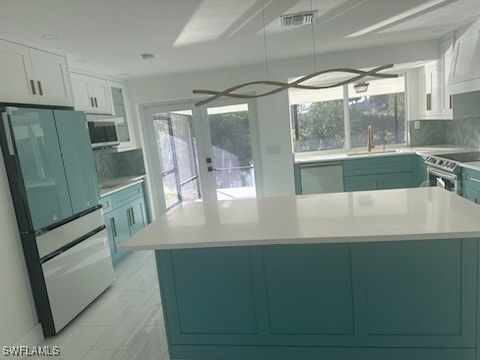 kitchen featuring backsplash, white cabinetry, sink, and appliances with stainless steel finishes