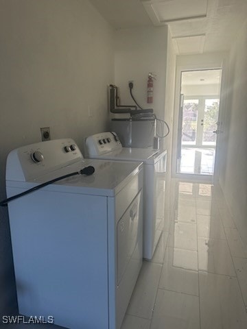 washroom featuring washing machine and dryer and light tile patterned flooring