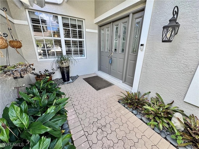 doorway to property featuring french doors and stucco siding