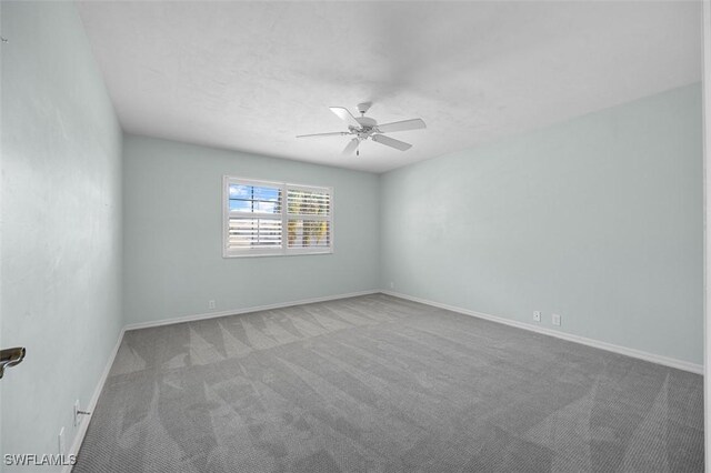 spare room with ceiling fan and carpet