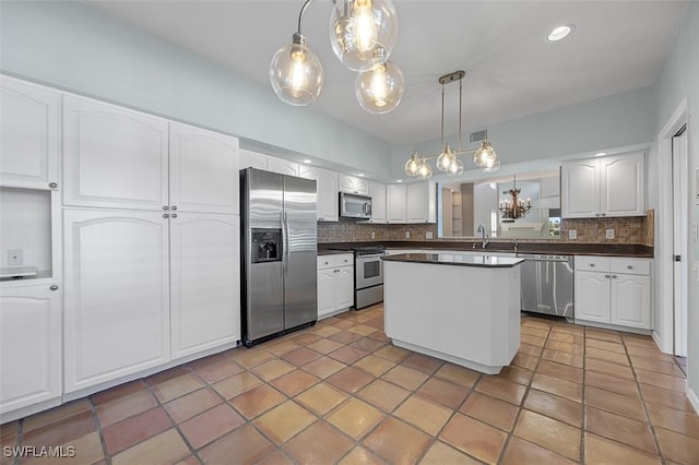 kitchen with decorative backsplash, sink, hanging light fixtures, stainless steel appliances, and white cabinets