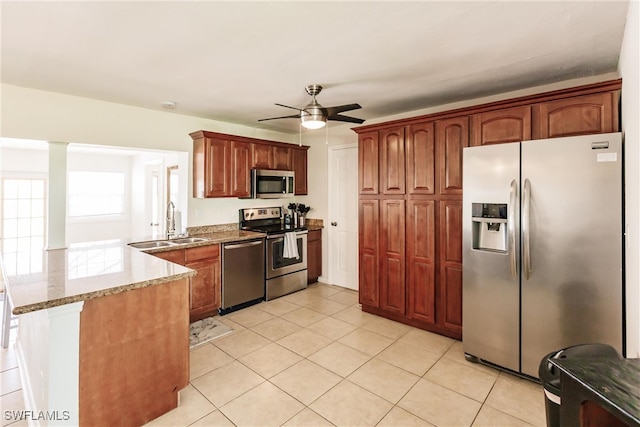 kitchen featuring kitchen peninsula, light tile patterned floors, ceiling fan, stone countertops, and stainless steel appliances