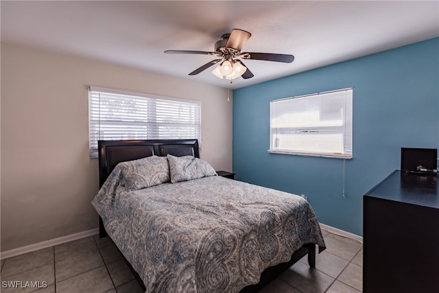 bedroom with multiple windows, light tile patterned flooring, and ceiling fan