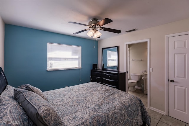 tiled bedroom with ensuite bath and ceiling fan