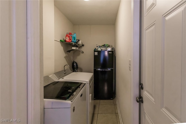 laundry area featuring light tile patterned floors and washing machine and clothes dryer