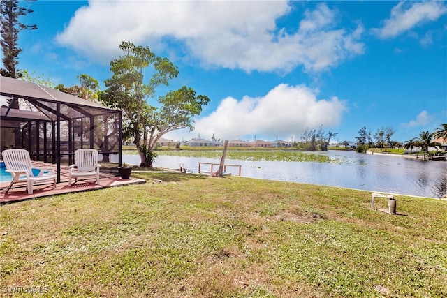 view of yard featuring a patio area, a water view, and a lanai