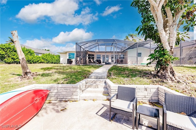 rear view of property with a patio area, a lanai, and a lawn