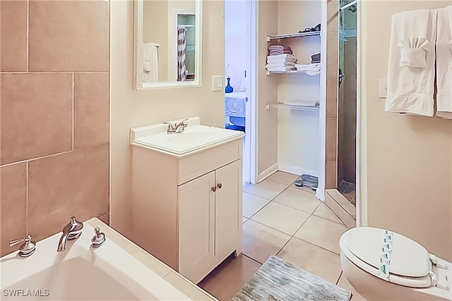 bathroom with toilet, vanity, and tile patterned flooring