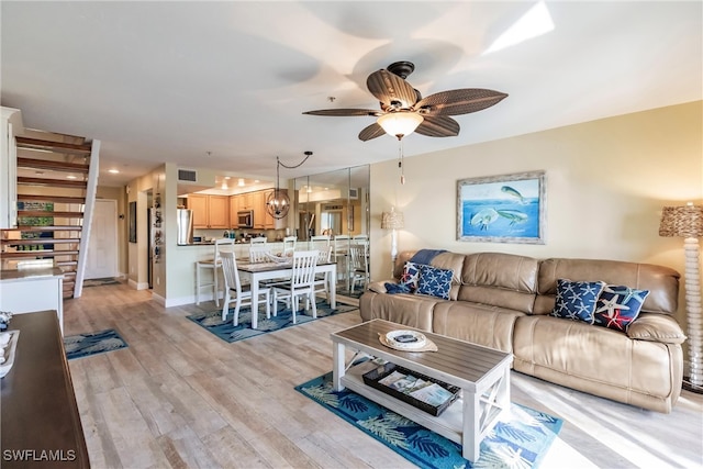 living room with light hardwood / wood-style floors and ceiling fan