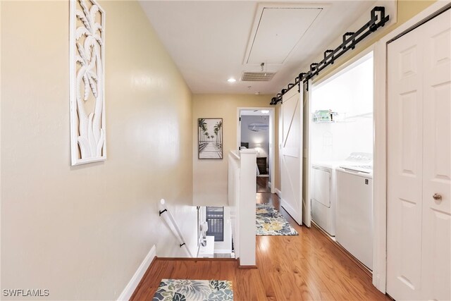 washroom with light hardwood / wood-style flooring and washing machine and clothes dryer