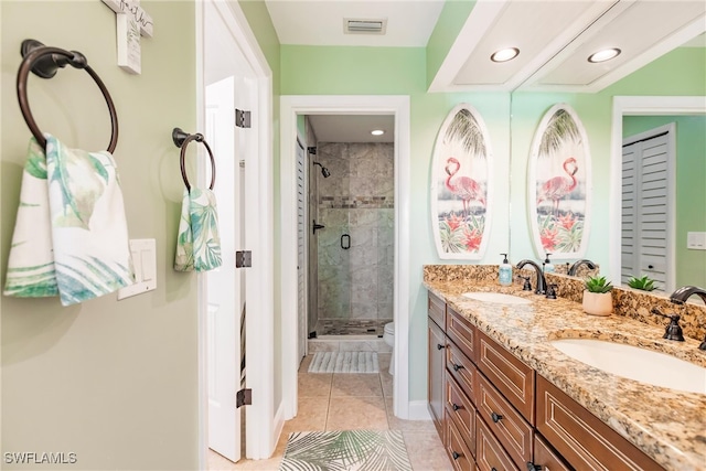 bathroom featuring a shower with door, vanity, toilet, and tile patterned floors