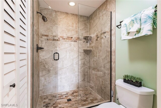 bathroom with toilet and an enclosed shower