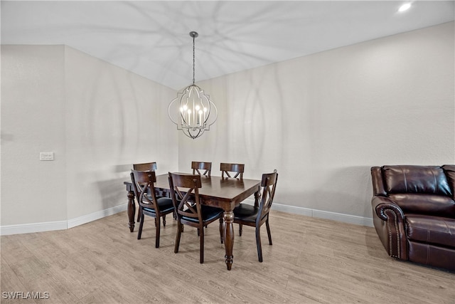 dining area with light hardwood / wood-style flooring and an inviting chandelier