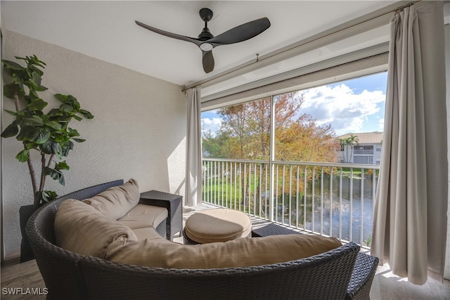 sunroom with a water view and ceiling fan