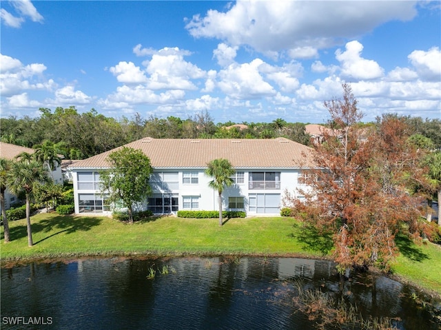 back of property with a yard and a water view