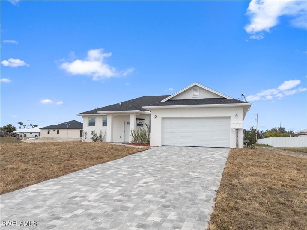 125 NW 18th Ave, Cape Coral, FL 33993 - ranch-style house with stucco siding, decorative driveway, and an attached garage
