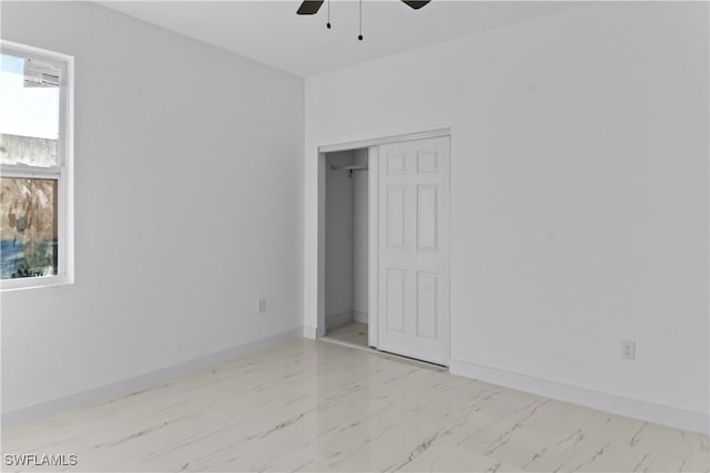 unfurnished bedroom featuring ceiling fan and a closet