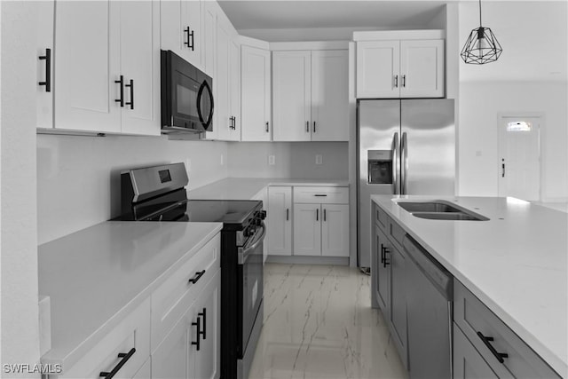 kitchen with decorative light fixtures, sink, white cabinetry, and appliances with stainless steel finishes