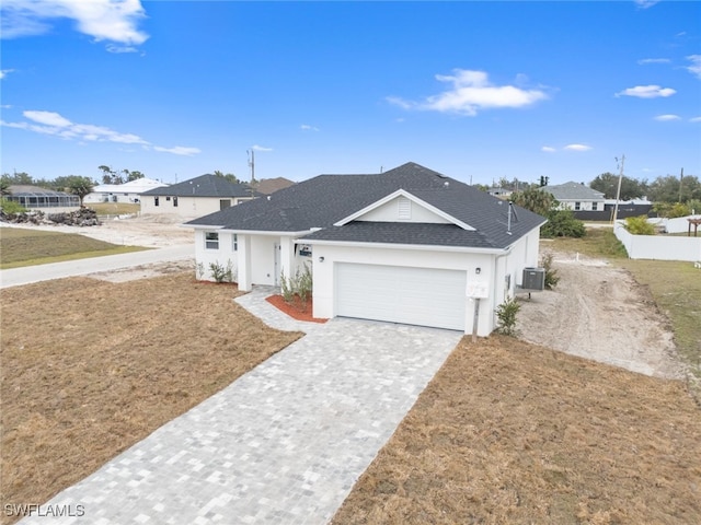 view of front of property featuring a front yard, cooling unit, and a garage