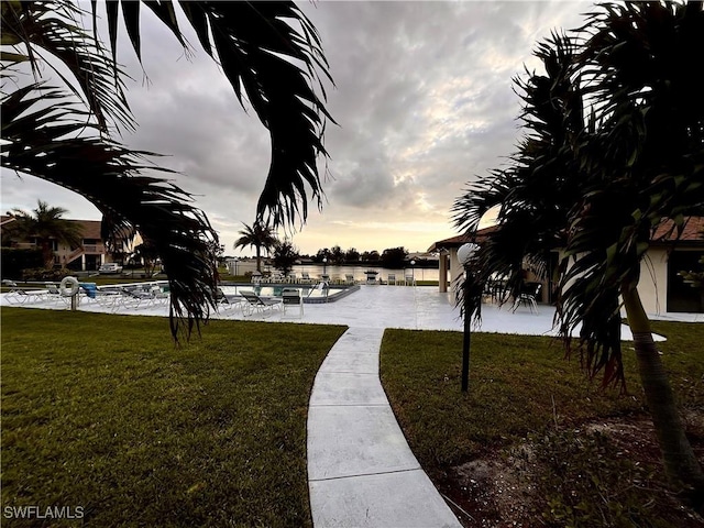 surrounding community featuring a water view and a lawn