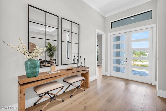 office with ornamental molding, light hardwood / wood-style floors, and french doors