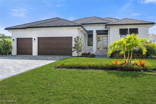 view of front of home with a garage, a front lawn, and french doors