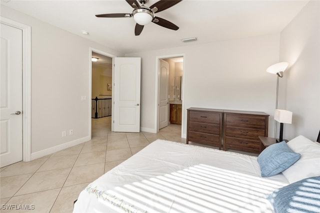 tiled bedroom with ensuite bath and ceiling fan