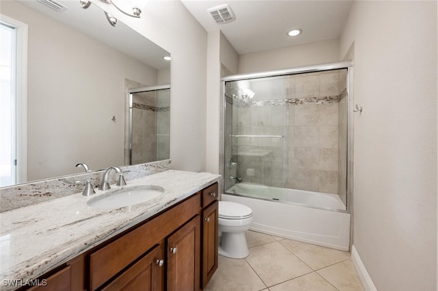 full bathroom featuring tile patterned flooring, vanity, combined bath / shower with glass door, and toilet