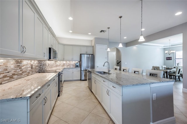 kitchen featuring pendant lighting, appliances with stainless steel finishes, a large island, and sink