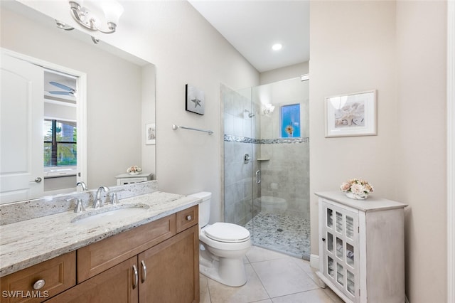 bathroom with tile patterned flooring, vanity, toilet, and walk in shower