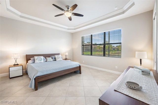 tiled bedroom featuring ceiling fan, ornamental molding, and a tray ceiling