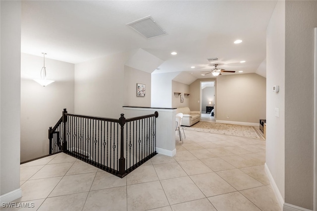 hall featuring light tile patterned floors and vaulted ceiling