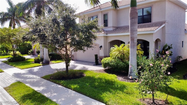 mediterranean / spanish house with a garage and a front yard