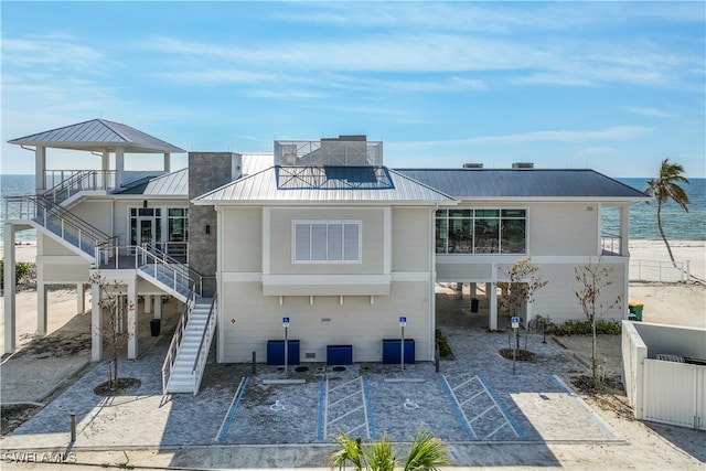 rear view of property featuring a view of the beach and a water view