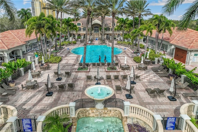 view of swimming pool with a hot tub, pool water feature, and a patio area