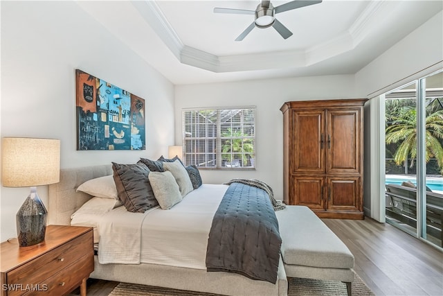 bedroom featuring crown molding, ceiling fan, light hardwood / wood-style floors, and a raised ceiling