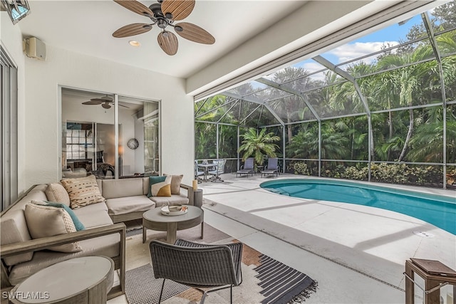 view of pool with a lanai, an outdoor living space, a patio area, and ceiling fan