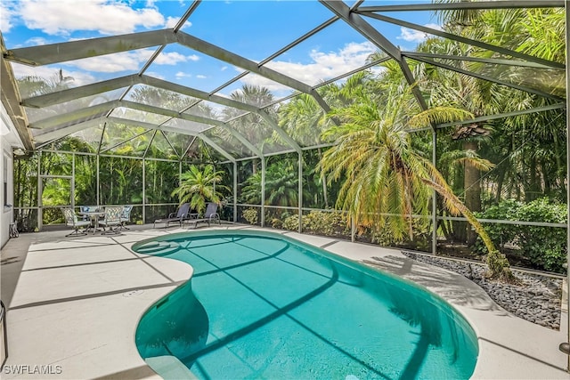 view of swimming pool with a patio area and glass enclosure