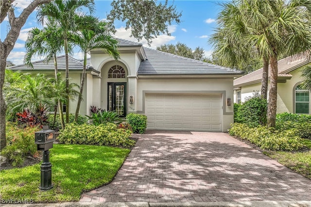 mediterranean / spanish-style home featuring a front yard and a garage